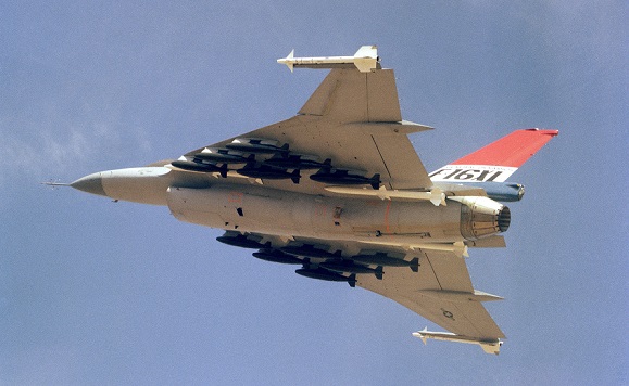 An air to air left underside view of an F-16XL aircraft.  The aircraft is armed with two wing tip mounted AIM-9 Sidewinder and four fuselage mounted AIM-7 Sparrow missiles along with 12 500-pound bombs.